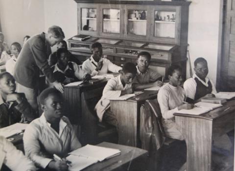 Prof. Josephine Nambooze (2nd R) attends a Science Class as the lecturer (standing) assists a student with his work in the 1950s, Makerere University, Kampala Uganda