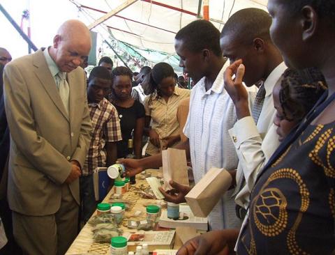 Chancellor Prof. Mondo Kagonyera listens to Botany students talk about pakaged medicinal plant remedies at the exhibition on Day 2 of the 3rd Stakeholders Consultative Conference, 26th to 27th March 2009, Makerere University, Kampala Uganda 
