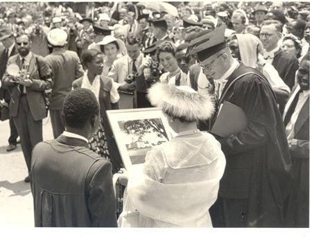 Her Majesty Queen Elizabeth, the Queen Mother and Principal Sir Bernard de Bunsen admire a framed portrait of the College at Makerere University, Kampala Uganda on 20th February 1959