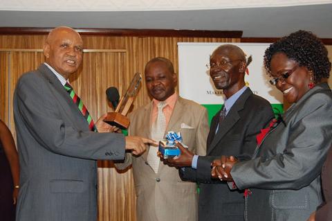 The Chancellor Prof. G.M. Kagonyera hands over an award to Prof. L.S. Luboobi (2nd R), former Vice Chancellor and after 43 years, is CoNAS' longest serving Professor, 20th July 2012, Kampala Serena Hotel, Uganda.