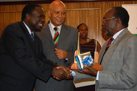 The Chairperson Council, Eng. Dr. C. Wana-Etyem (L) congratulates Prof. H. Oryem-Origa (R), former Dean, Science and long serving Professor of Botany, 20th July 2012, Kampala Serena Hotel, Uganda.