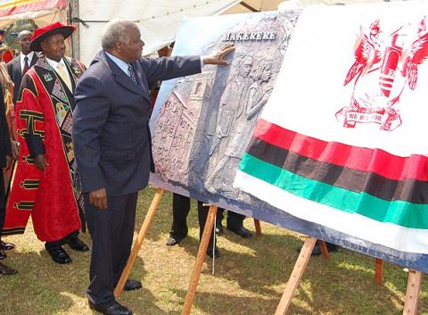 H.E. President Mwai Kibaki of Kenya (R) gets a feel of the artwork of the plaque symbolizing the Launch of Constituent Colleges on 24th January 2012, Makerere University, Kampala Uganda.