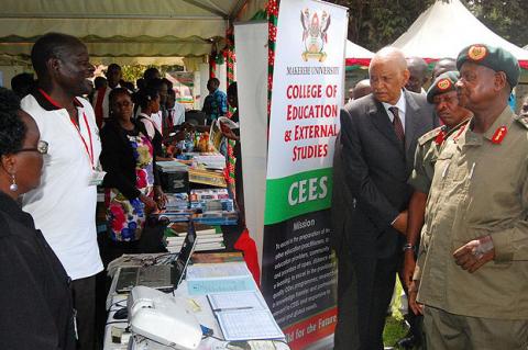 Mr. Titus Okumu, E-Learning Manager explains the platform's importance to President Museveni as he visited the College of Education and External Studies (CEES) stall during his tour of the exhibition on 4th August 2012, Makerere University, Kampala Uganda.