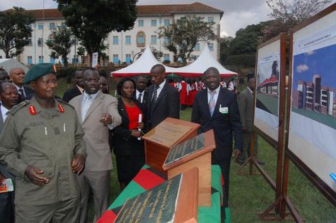 President Museveni guided by the Acting Vice Chancellor Prof. V. Baryamureeba (2nd L) and Estates Manager, Mr. F. Nuwagaba (R) admires artistic impressions of four buildings to be constructed shortly after laying their Foundation stones on 4th August 2012, Makerere University, Kampala Uganda.