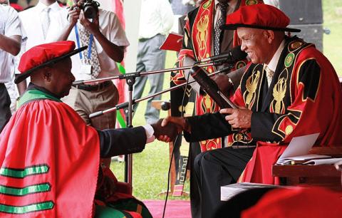 H.E. President Yoweri Museveni receives his Honorary Doctorate of Laws Award Letter from The Chancellor Prof. George Mondo Kagonyera during the Award Ceremony on 12th December 2010, Makerere University, Kampala Uganda.