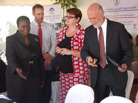 Dr. Jane Bosa (L) ushers U.S. Ambassador Scott DeLIsi to his seat during the SMC Launch on 11th December 2012, Makerere University Hospital, Kampala Uganda.
