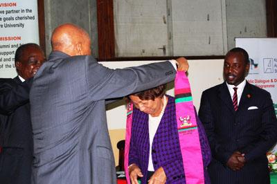 The Chancellor Prof. Mondo Kagonyera adorns Mrs. Aliker with a Makerere scarf.