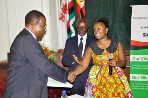 The Chief Guest Prof. Ephraim Kamuntu (L) receives a gift from the Mugyenyi Family during the 2nd Joshua Mugyenyi Memorial Lecture, 15th March 2013, Makerere University, Kampala Uganda.