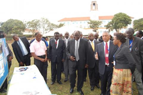Dr. Alex Coutinho, ED-Infectious Diseases Institute (IDI), CHS (2nd R) conducts H.E. Dr. Mwai Kibaki (C) and Rt. Hon. Amama Mbabazi around the IDI stall during the Mak@90 Grand Finale Exhibition, 3rd August 2013, Makerere University, Kampala Uganda.