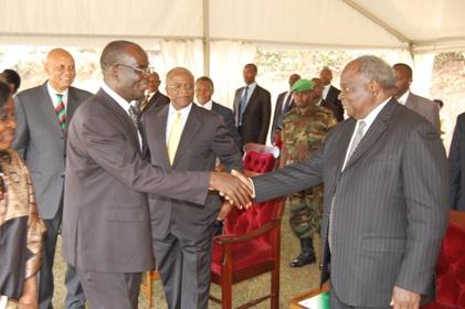 Mr. Mutekanga Igaga (L) is congratulated upon his recognition as Composer of the Makerere Anthem by Former Kenyan President and Alumnus H.E. Mwai Kibaki (R) during the Mak@90 Grand Finale Celebrations, 3rd August 2013, Freedom Square, Makerere University, Kampala Uganda.