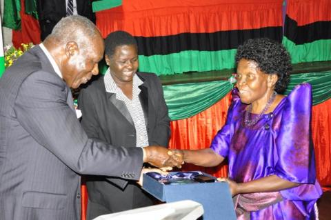 Former Education Minister Hon. Namirembe Bitamazire (R) receives her award from Former UEA Council Chairperson Dr. Martin Aliker at the UEA 50th Anniversary celebrations 29th June 2013, Makerere University, Kampala Uganda.